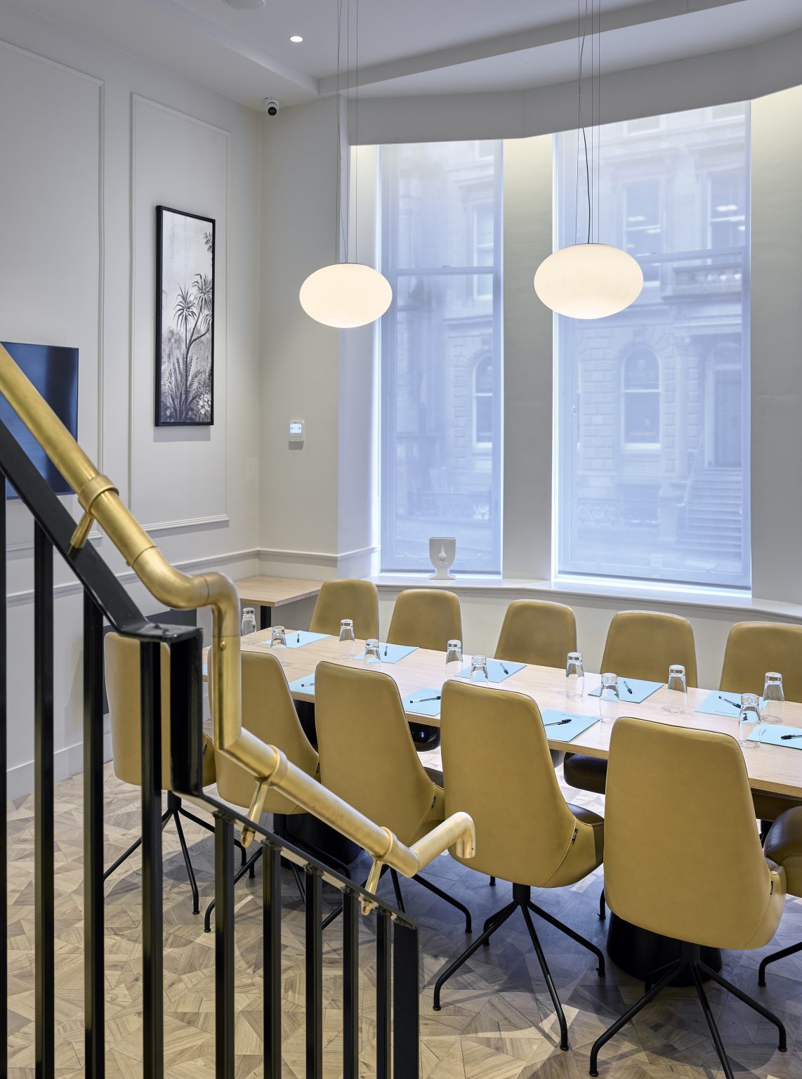 Bright meeting space with a large table and upholstered chairs, designed for comfort in hospitality settings.