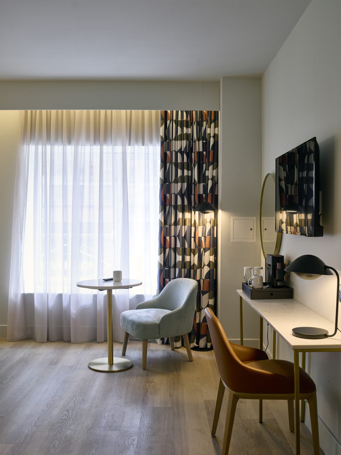 Comfortable guest seating area with armchair and window-side table, enhancing relaxation in the hospitality fit-out.