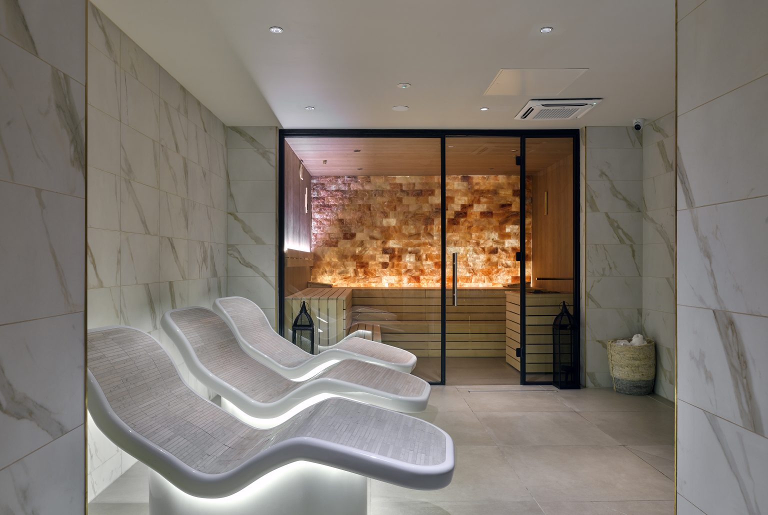 Luxury spa fit-out featuring heated relaxation loungers and a Himalayan salt sauna room for a serene wellness experience.