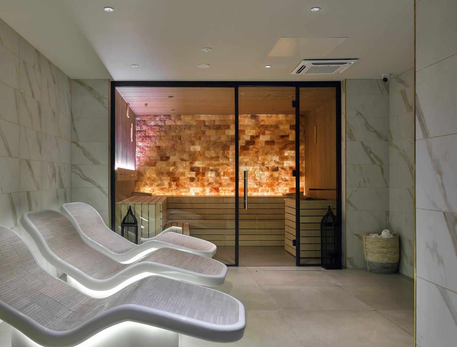 Luxury spa fit-out featuring heated relaxation loungers and a Himalayan salt sauna room for a serene wellness experience.