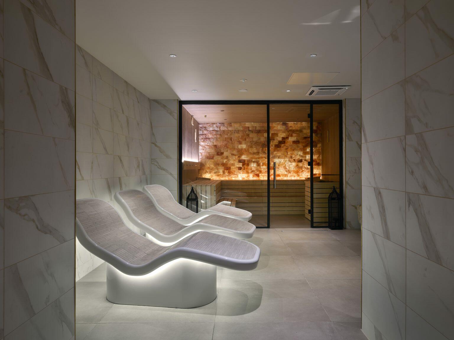 Luxury spa fit-out featuring heated relaxation loungers and a Himalayan salt sauna room for a serene wellness experience.