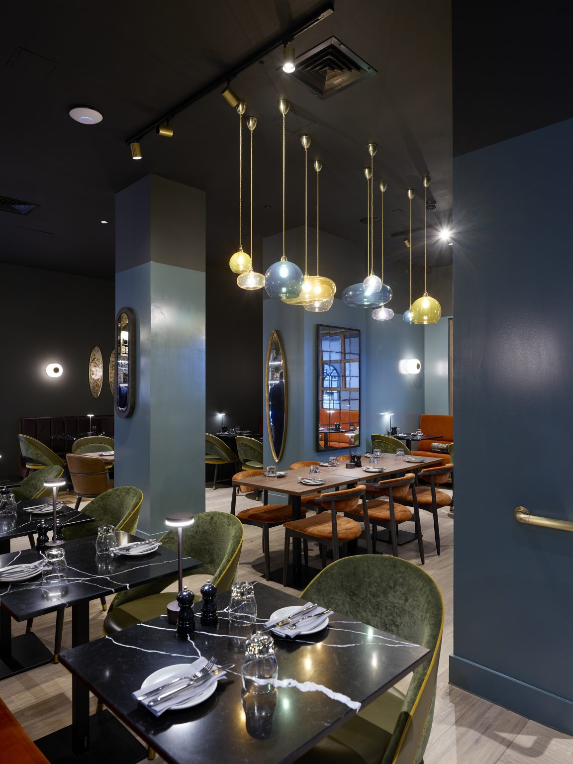 Vibrant pendant lighting installation above restaurant tables, showcasing bespoke hospitality fit-out details.