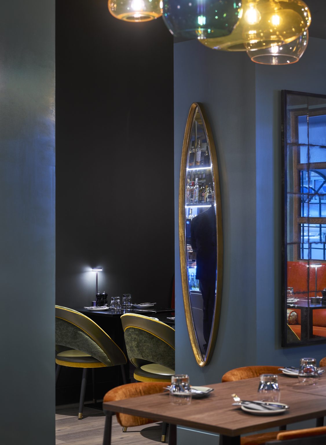 Intimate dining space with mirrors and ambient lighting, designed for an upscale hospitality fit-out.