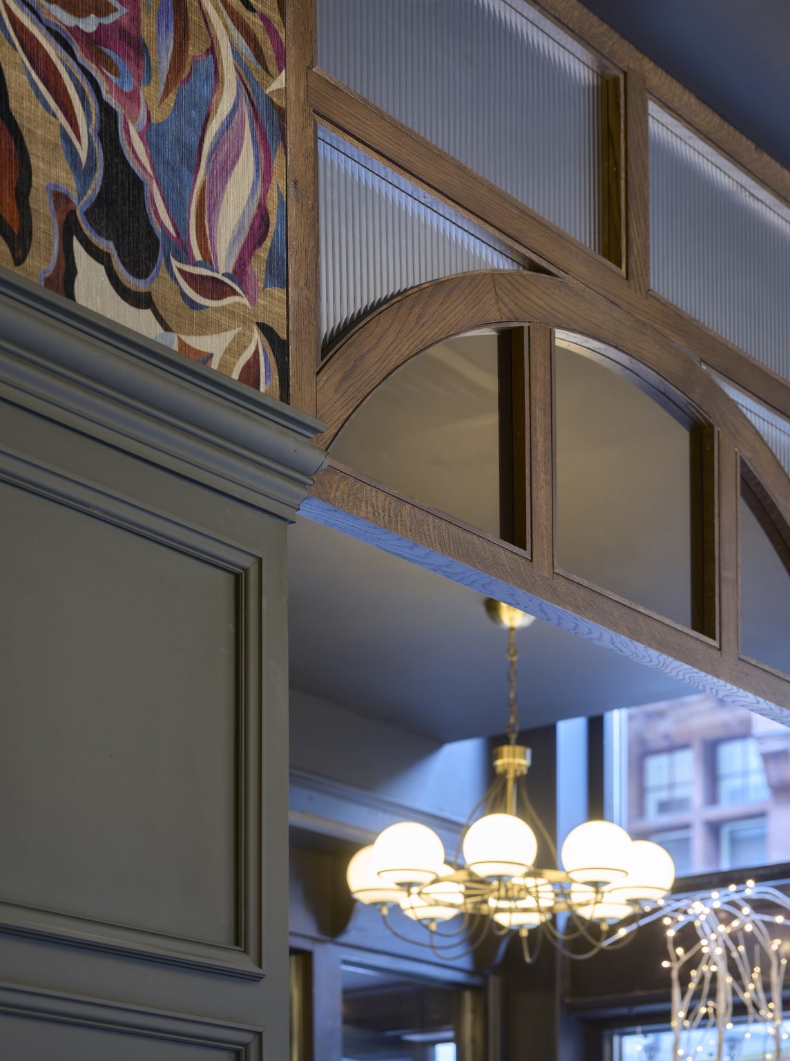 Architectural detailing in hospitality fit-out, featuring custom wood panelling and decorative lighting.